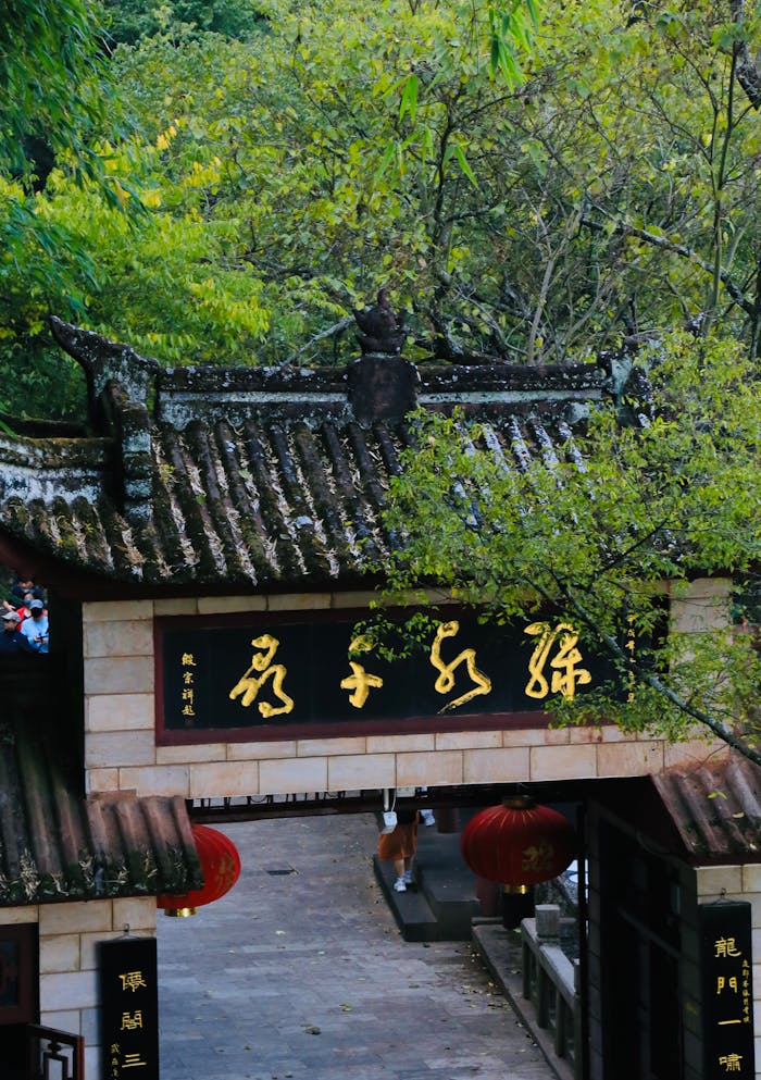 about-02 Beautiful traditional Asian temple entrance surrounded by lush greenery, creating a serene atmosphere.