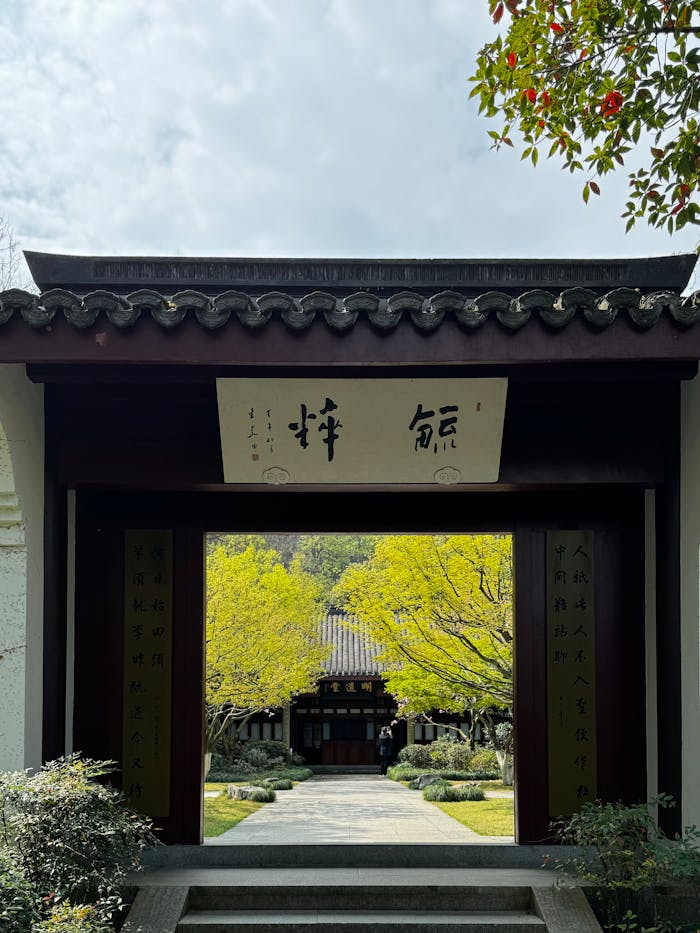 A serene entrance with calligraphy leading to a traditional Chinese garden.