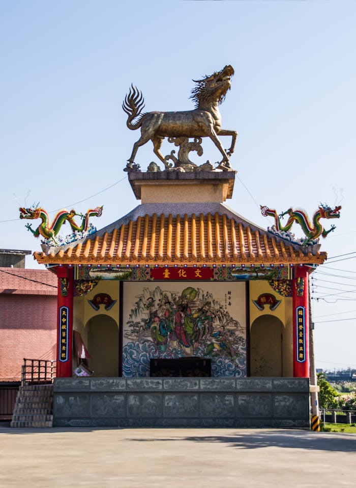 A traditional Chinese temple featuring a rooftop sculpture and colorful dragon decorations.
